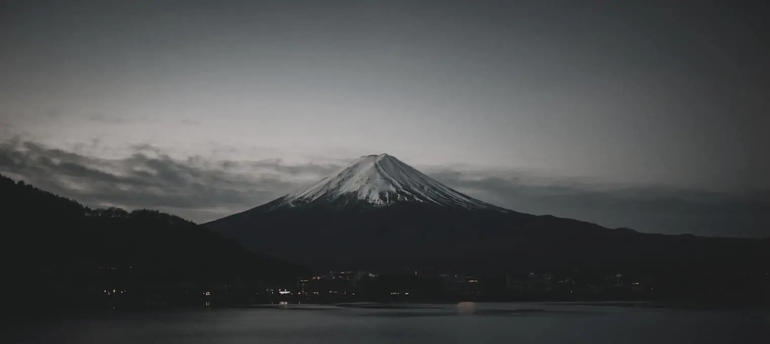 Lago y montaña al amanecer bajo una luz fría y apagada