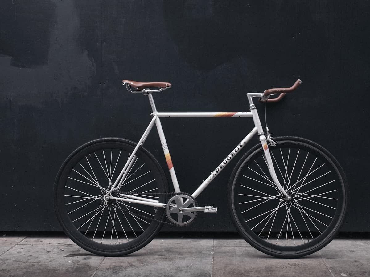 Bicicleta apoyada contra un muro oscuro en una calle vacía